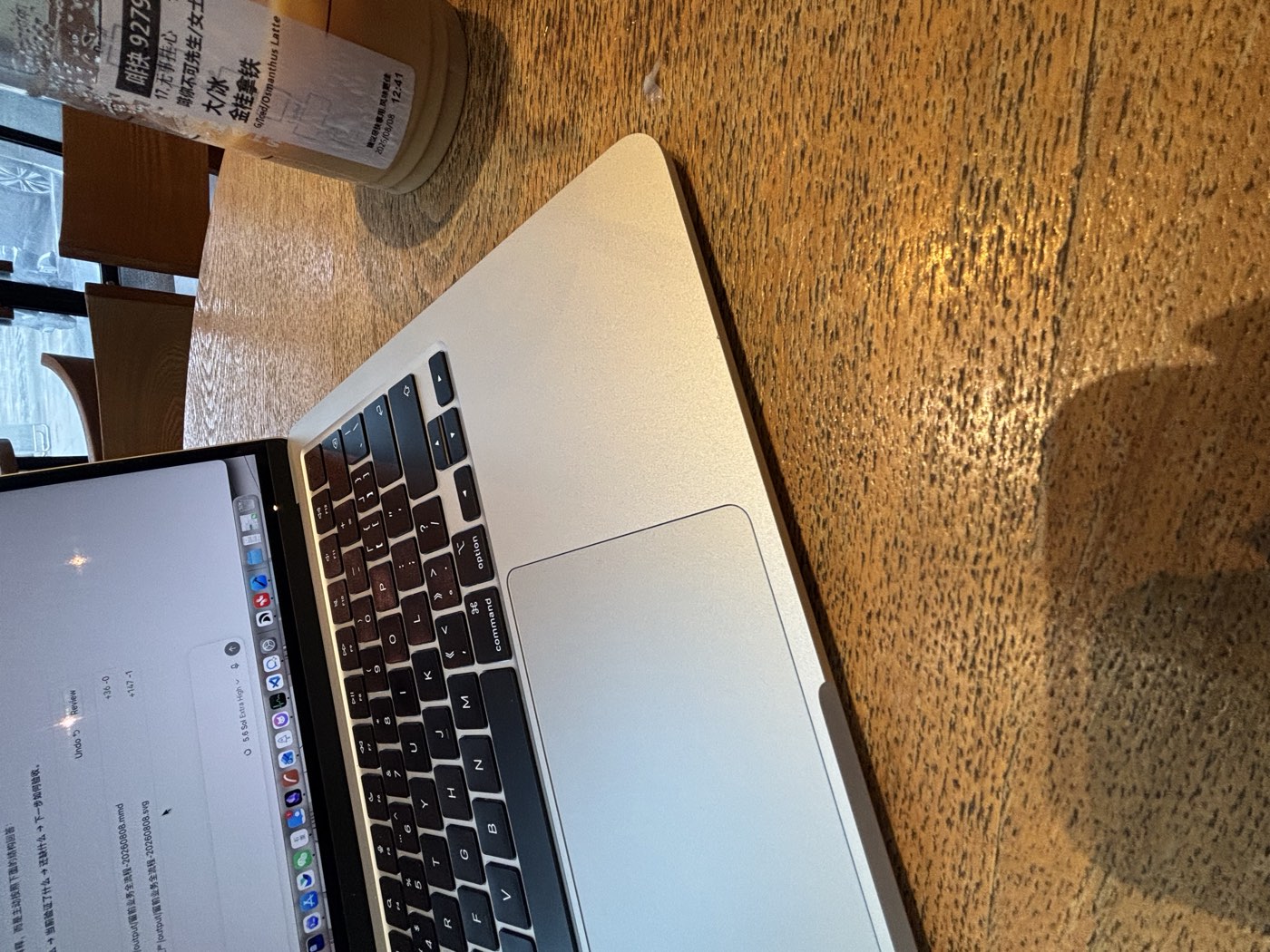 星巴克的木桌上摊着 MacBook，旁边一杯冰金桂拿铁