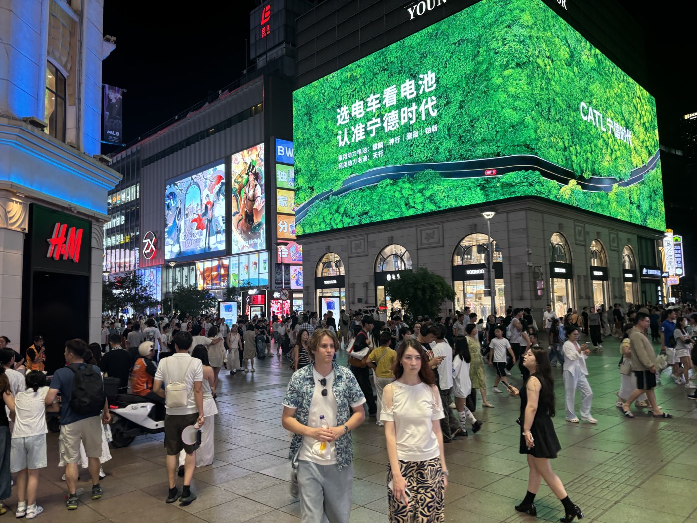夜晚的南京路步行街，人流、店铺招牌和巨大的曲面 LED 屏